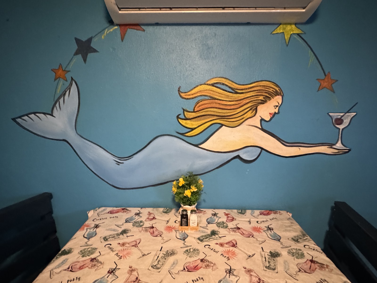 Mural de una sirena pintado a mano sobre una mesa del comedor